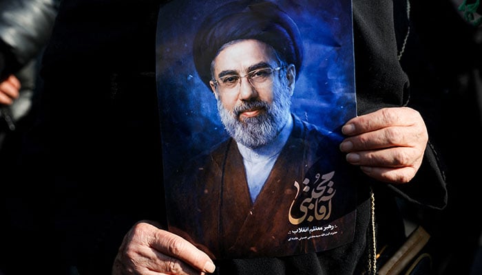 A woman holds a portrait of Irans new supreme leader Mojtaba Khamenei, on the day of a gathering to support Mojtaba Khamenei, amid the US-Israeli conflict with Iran, in Tehran, Iran, March 9, 2026. — Reuters