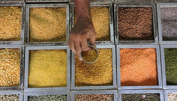 An employee collects lentils from a container inside a grocery store. — Reuters/File