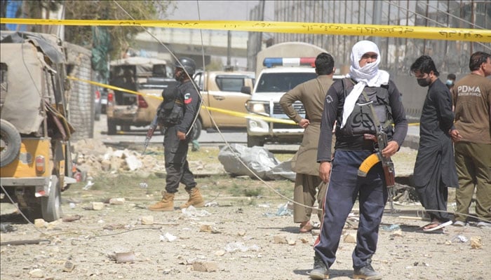 Security and rescue workers standing at the blast site near Chainak Chowk in Sibi. —Anadolu Agency