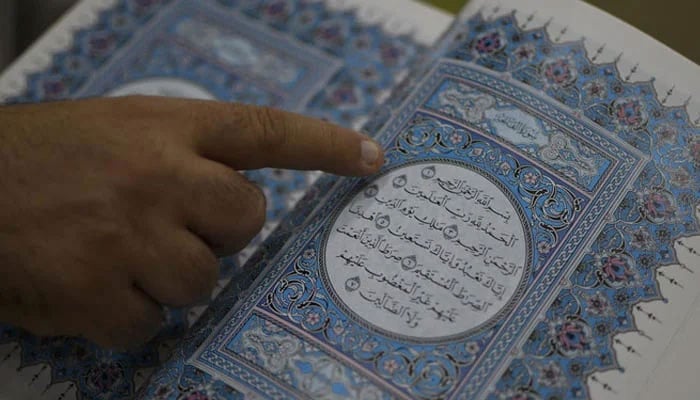 This representational image shows a person reciting the Holy Quran. — AFP/File