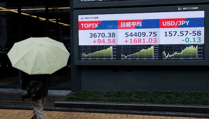 A pedestrian looks at a stock quotation board showing the Topix average, the Nikkei share average, and the exchange rate between Japanese yen and U.S. dollar outside a brokerage in Tokyo, Japan, March 10, 2026.—Reuters