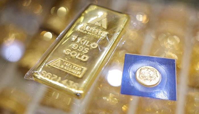 A one-kilogram gold bar and a sealed gold coin are displayed at a jewellery store, in Dubai, United Arab Emirates, January 20, 2026. — Reuters