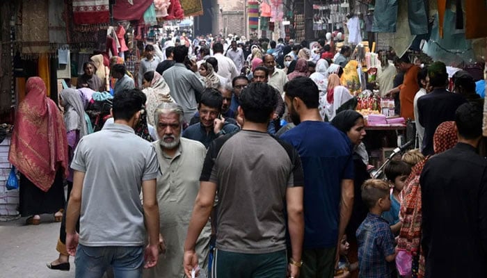 This representational image taken on April 16, 2023, shows people thronging a market area in Lahore. — AFP