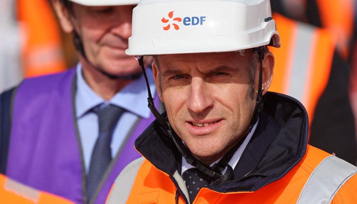 CEO of French energy group EDF Bernard Fontana (L) and Frances President Emmanuel Macron (R) attend a visit of the EPR2 new generation reactors construction site at the Penly nuclear power plant in Petit-Caux on the English channel coast on March 12, 2026. — AFP