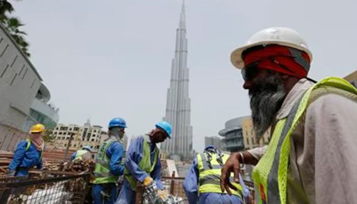 Labourers work near the Burj Khalifa, the tallest tower in the world, in Dubai in this May 9, 2013 photo. — Reuters