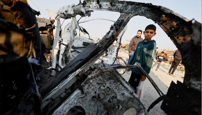 Palestinians inspect the site of an Israeli airstrike targeting a police vehicle in the central Gaza Strip, March 15, 2026. —Reuters