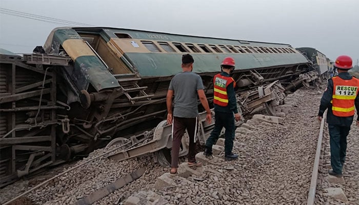 Rescue workers passing by the train accident site. —APP/File