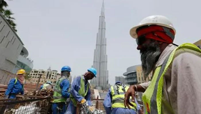 Labourers work near the Burj Khalifa, the tallest tower in the world, in Dubai in this May 9, 2013 photo. — Reuters
