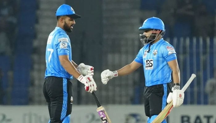 Karachi Whites Abdullah Fazal (left) and Saud Shakeel bump fists during their National T20 Cup semi-final against Sialkot at the Imran Khan Cricket Stadium in Peshawar on March 17, 2026. — PCB
