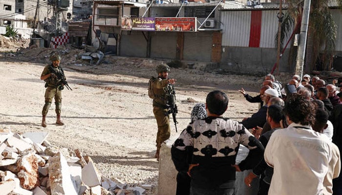 Residents of the Nur Shams refugee camp, near Tulkarem in the Israeli-occupied West Bank, argue with Israeli soldiers as they protest at the entrance of the camp demanding the right to return to their homes, on November 18, 2025. —AFP