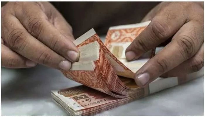 A person is counting Rs5,000-rupee notes from a stack. — AFP/File