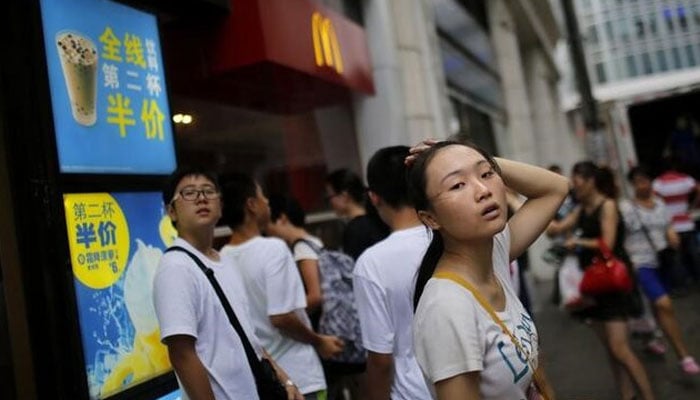 Customers stand outside of a McDonalds store in downtown Shanghai July 31, 2014. — Reuters
