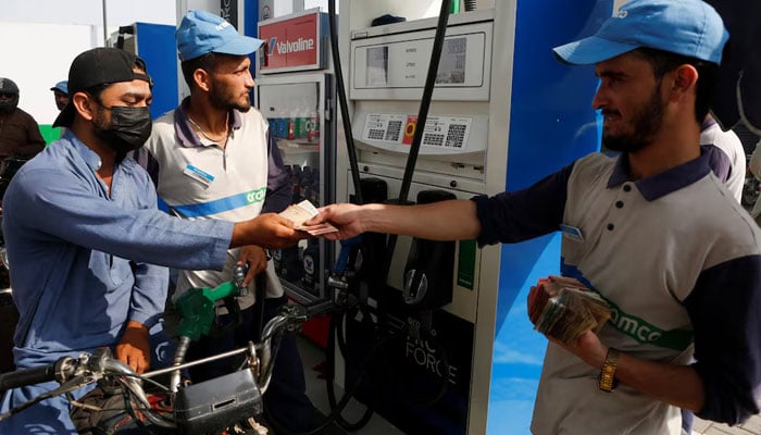 Malik Mohsin Ali, a rider for Bykea, a ride-hailing and delivery platform, pays for fuel at a petrol station in Karachi, Pakistan, March 18, 2026. — Reuters