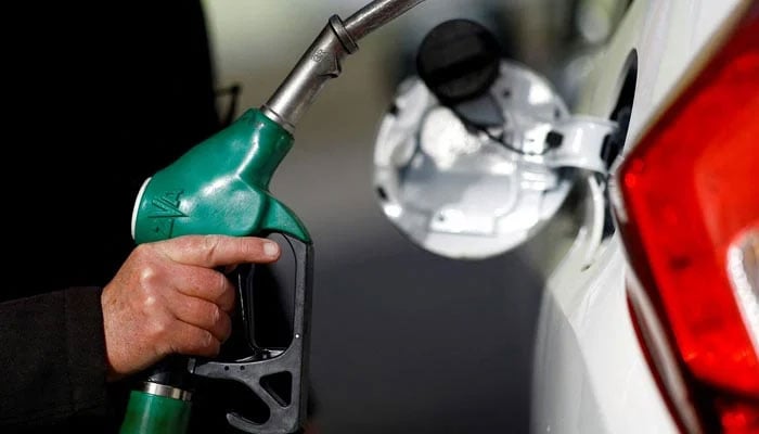The representational image shows a man holding a fuel nozzle at a petrol station. — Reuters/File