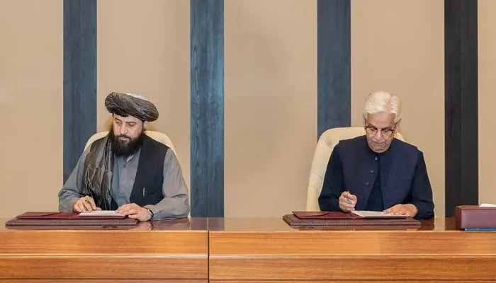 Defence Minister Khawaja Muhammad Asif (right) and Afghan Defence Minister Mullah Mohammad Yaqoob Mujahid sign the ceasefire agreement in Doha on October 19, 2025. — Reuters