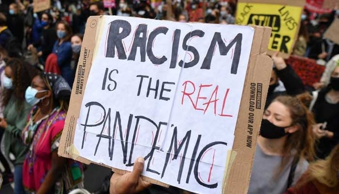 People hold placards on the inaugural Million People March on August 30, 2020. — AFP