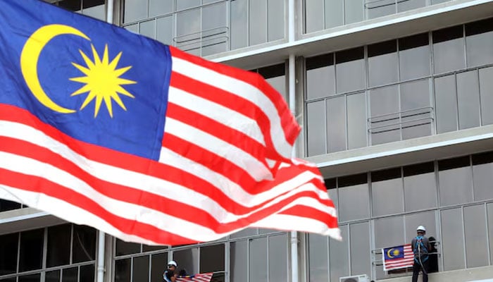 Workers hang Malaysian flags ahead of celebrations for the country’s 62nd anniversary of independence on August 31 in Kuala Lumpur, Malaysia, July 31, 2019. — Reuters