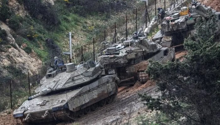 Israeli soldiers lean out from a tank to inspect a disabled tank stuck in the mud, on the Israeli side of the border with Lebanon, amid escalation between Iran-backed Hezbollah and Israel and the U.S.-Israeli conflict with Iran, in northern Israel, March 21, 2026. —Reuters