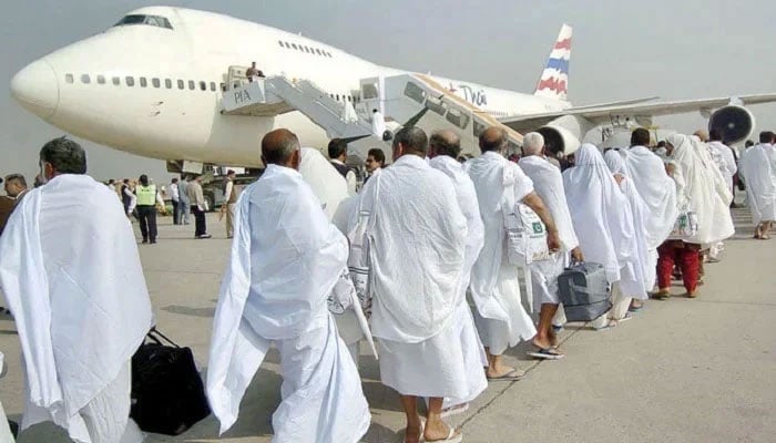 Muslim pilgrims walk towards a waiting plane at an airport bound for Saudi Arabia to perform the annual Hajj pilgrimage.— AFP/File