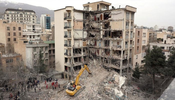 Rescue workers using heavy machinery to remove debris caused by Israel-US attacks on Iran.—AFP/File