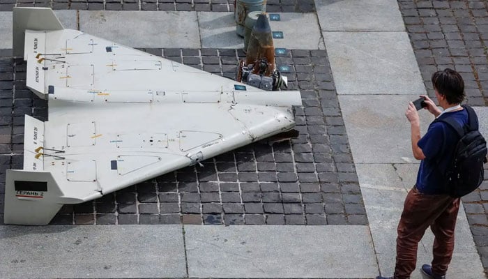 A visitor at an exhibition in Kyiv photographs parts of an Iranian-made Shahed-131/136 drone. —Reuters