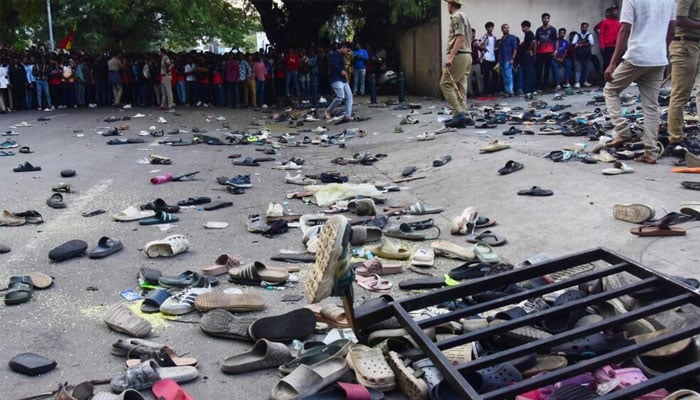 Fans stand next to abandonned shoes and a fallen barrier outside M. Chinnaswamy Stadium. — AFP/File