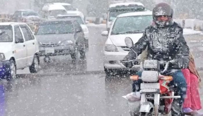 Commuters travel during light snow in Punjab. — AFP/File