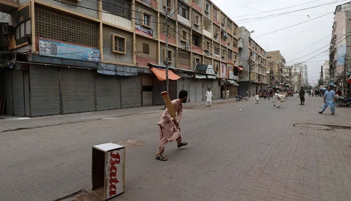 Shopkeepers play cricket along closed market during a partial lockdown after Sindh provincial government decided to shut markets, restaurants, public beaches and discouraged large gatherings to curb the outbreak of the coronavirus disease (COVID-19), in Karachi, July 30, 2021. — Reuters