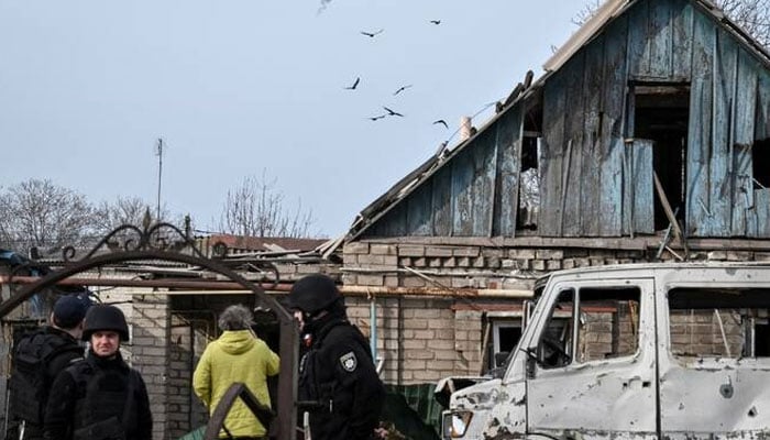 Ukrainian servicemen hit a Russian drone as police officers work at the site of a building hit by a Russian drone strike, in Zaporizhzhia, Ukraine. —Reuters/File