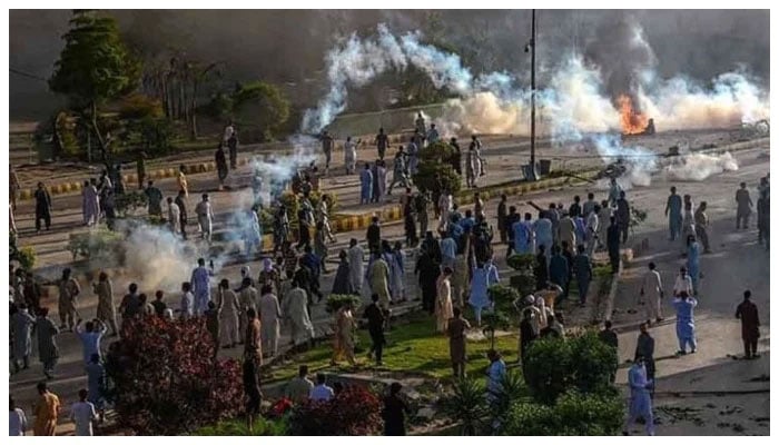 Police fire teargas shell towards Pakistan Tehreek-e-Insaf party activists and supporters of former Pakistan Prime Minister Imran to disperse them during a protest against the arrest of their leader on May 9, 2023. — AFP