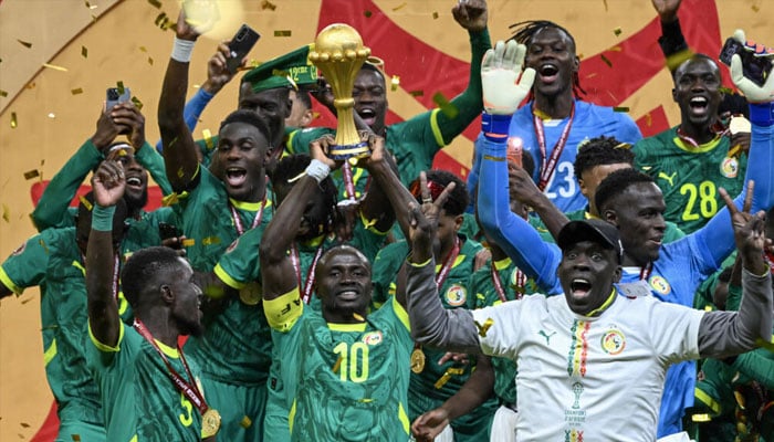 Senegals Sadio Mane, surrounded by teammates, holds the Africa Cup of Nations trophy aloft after his teams 1-0 win over Morocco in the final in Rabat in January. —AFP/File