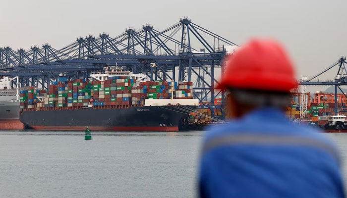 A worker looks on near a cargo ship carrying containers at the Yantian port in Shenzhen, Guangdong province, China May 9, 2025.