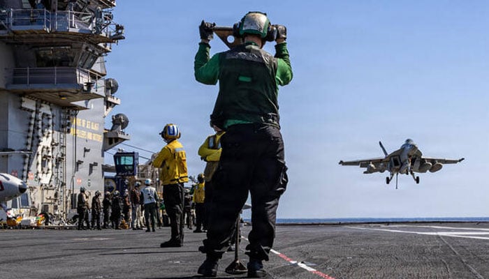 US sailors watch as an F/A-18E Super Hornet aircraft, assigned to Strike Fighter Squadron 31, approaches the flight deck of the worlds largest aircraft carrier, USS Gerald R. Ford on March 8. — AFP/File