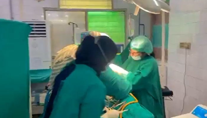 The image shows doctors busy in C-section operation at the Lady Wellington Hospital, Lahore. — X@aliafzalsayal/Screengrab