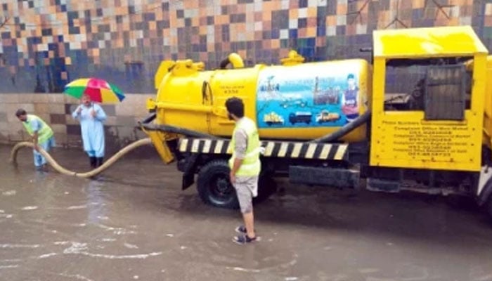 The Water and Sanitation Agency (WASA) workers clear rain water from the city. — APP/File