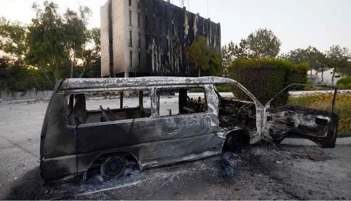 Smoke billows from a Radio Pakistan building next to a burnt vehicle after it was set afire by the supporters of Pakistans former Prime Minister Imran Khan during a protest against his arrest, in Peshawar, Pakistan, May 10, 2023. — Reuters