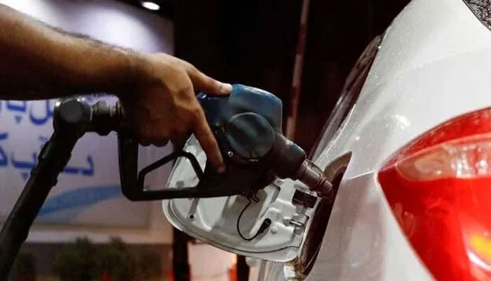 A worker holds a fuel nozzle to fill fuel in a car at petrol station in Karachi on September 16, 2023. — Reuters
