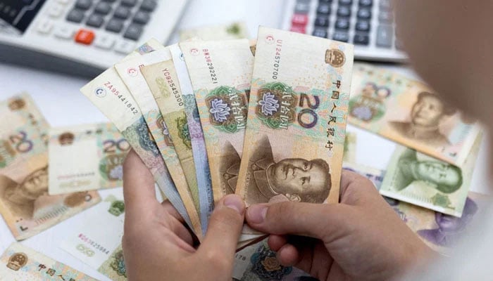 A woman holds Chinese yuan banknotes in this illustration taken May 30, 2022. — Reuters