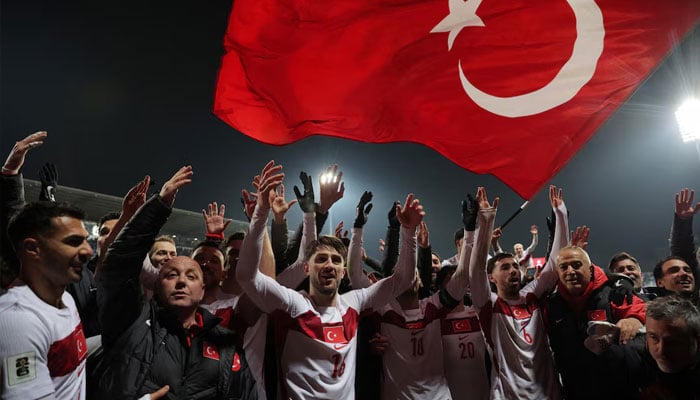 Turkeys Orkun Kokcu and Ismail Yuksek celebrate with team after qualifying for the FIFA World Cup, March 31, 2026. —Reuters