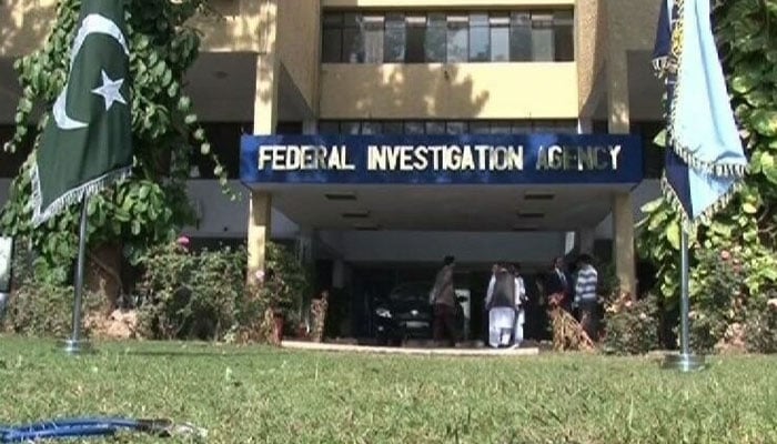 Officials stand outside Federal Investigation Agency (FIA) building. — The News/File