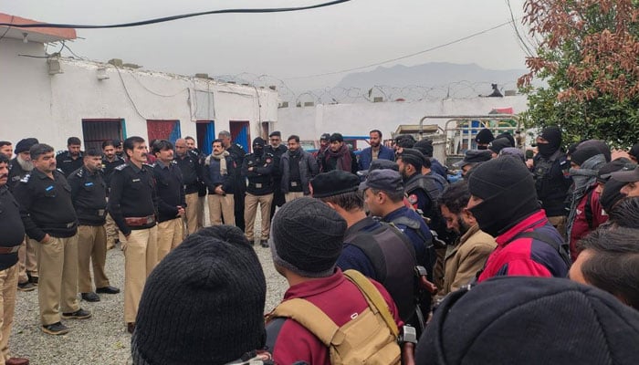 The image shows police personnel getting ready for action against illegal placer gold mining in Nowshera on December 30, 2025. — Facebook@ADM705DAWAR