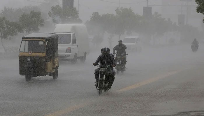 Commuters travel on a road during heavy rain in Karachi, on August 20, 2025. — Reuters