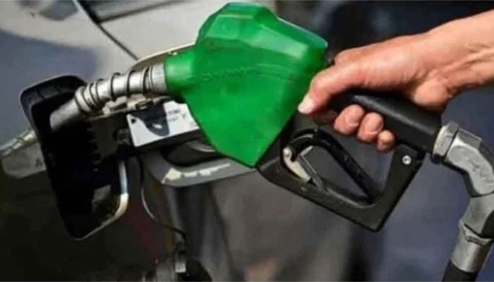 A representational image of a man holding a fuel nozzle at a petrol station. — AFP/File