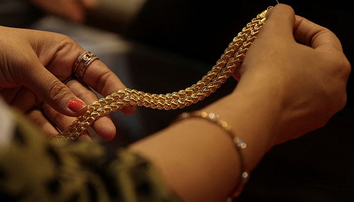 A customer holds a gold chain at a jewellery store in Mumbai, India, January 30, 2026. — Reuters