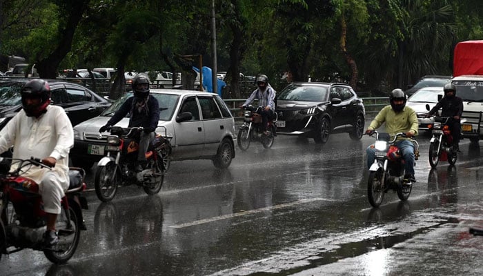 Vehicles are seen on their way during rain in Lahore on April 4, 2026. — APP