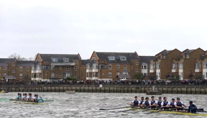 The Cambridge crew and the Oxford crew (R) competing during the 171st mens University boat race on Londons River Thames. —AFP