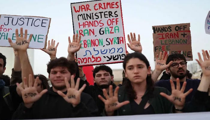 Israeli left-wing activists hold placards while taking part in a protest at HaBima Square in Tel Aviv on April 4, 2026, against the ongoing war with Iran.— AFP
