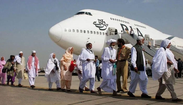 Pilgrims walk in line as they prepare to board a Pakistan International Airlines special Hajj pilgrimage flight bound for Saudi Arabia at the Allama Iqbal International airport in Lahore. — AFP/File