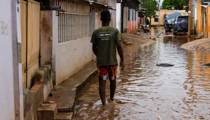 An African passing through a street filled with rainwater. —AFP/File