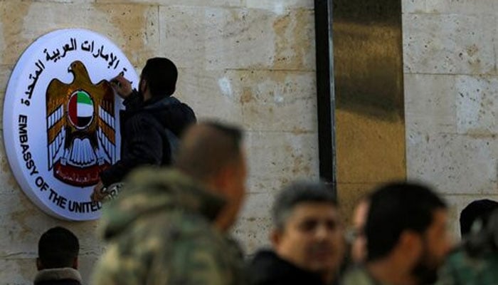 A man works on the emblem of the United Arab Emirates embassy in Damascus during its reopening, Syria December 27, 2018. — Reuters